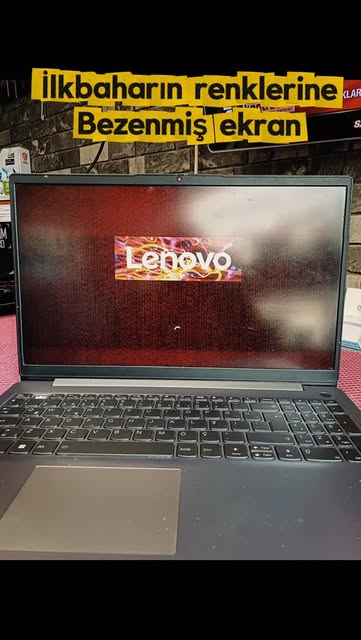 Ekranında kırmızı çizgiler ve bozuk görüntü olan, açılış logosunda kalmış bir Lenovo notebook